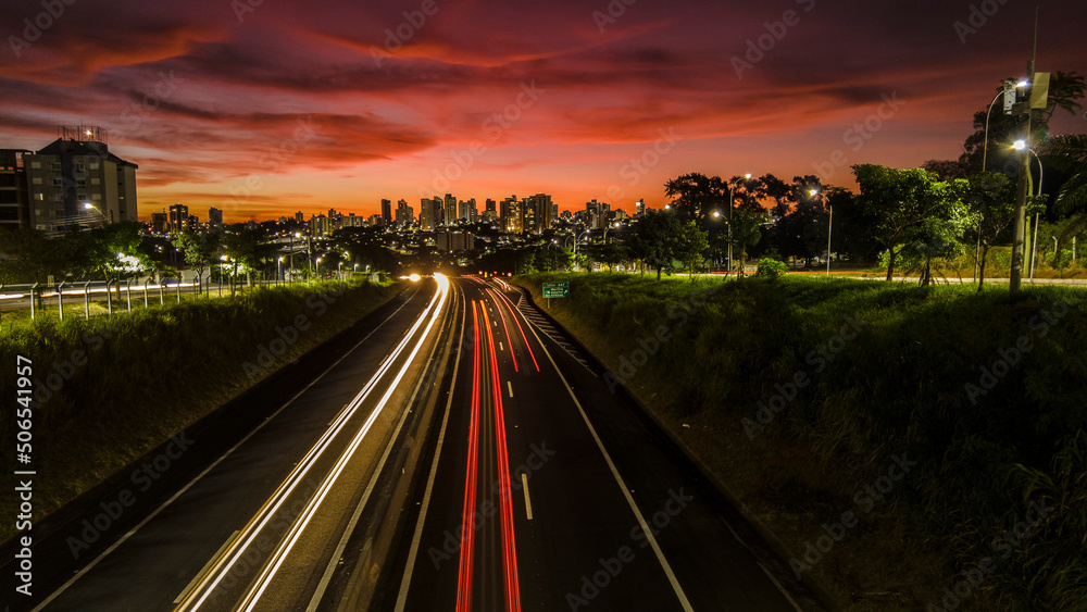 Trail of light caused by vehicular traffic in SP-294, Comandante Joao Ribeiro Barros Highway with buildings from downtown in the background, in Marília, Trail of light caused by vehicular traffic in SP-294, Comandante Joao Ribeiro Barros Highway with buildings from downtown in the background, in Marília,