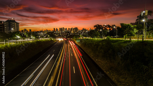 Trail of light caused by vehicular traffic in SP-294  Comandante Joao Ribeiro Barros Highway with buildings from downtown in the background  in Mar  lia 
