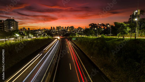 Trail of light caused by vehicular traffic in SP-294, Comandante Joao Ribeiro Barros Highway with buildings from downtown in the background, in Marília,