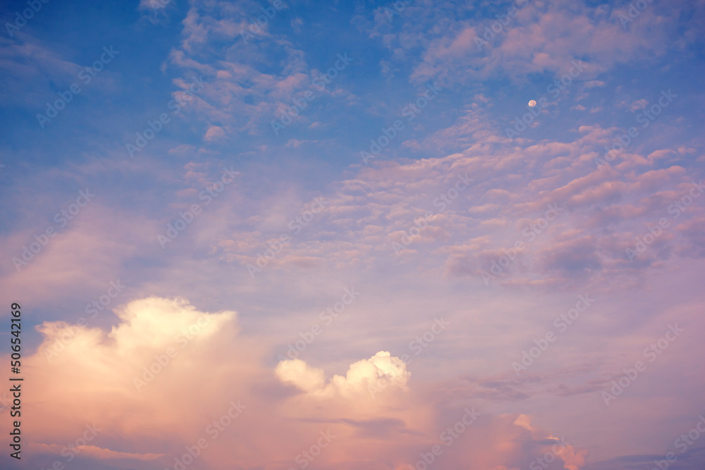 Pink clouds on blue sky with shining moon. Fabulous background for design. Wallpaper with fantastic morning sky.