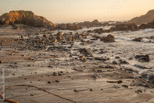 warm sunset over receding tide of the pacific ocean