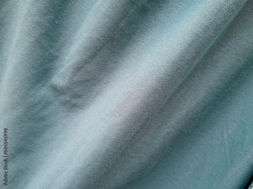 Abstract blue textured fabric background exposed to sunlight so that shadows are formed