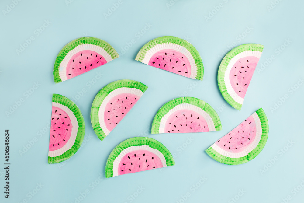 Fruit made of paper - watermelon. Blue background. Tropics creative concept, kindergarten, daycare handmade papercraft, summer season, sweet food. Flat lay.