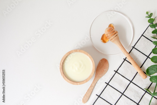 Natural ingredients for homemade face mask, top view of yoghurt and honey on white background, beauty skincare product concept, flat lay