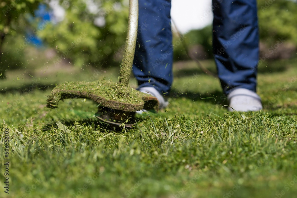 Banner. A human lawn mower cuts the grass in the backyard