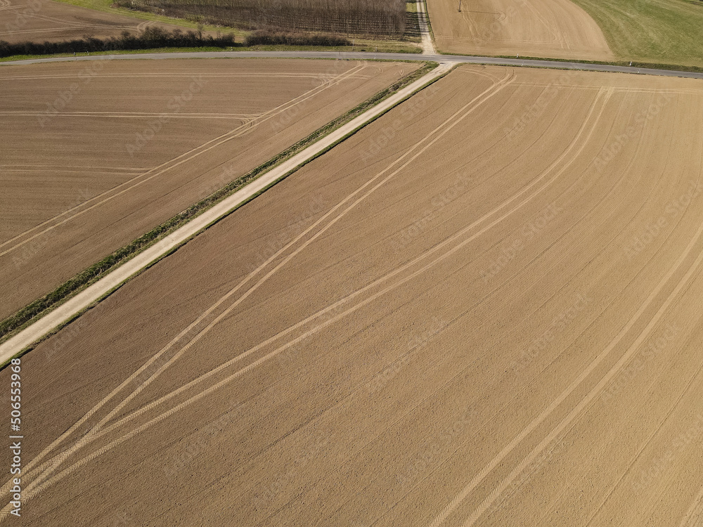 Fototapeta premium Aerial view of freshly plowed agricultural fields in spring