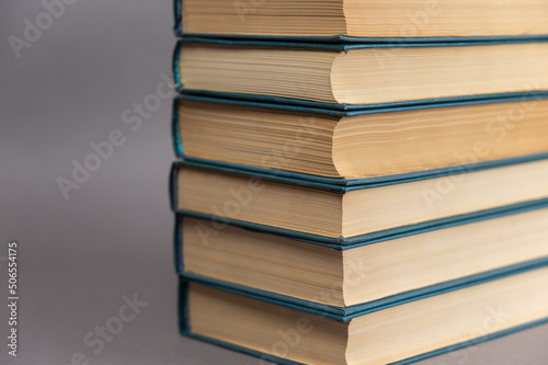 A stack of blue-covered books against a gray background. A group of hardcover books.