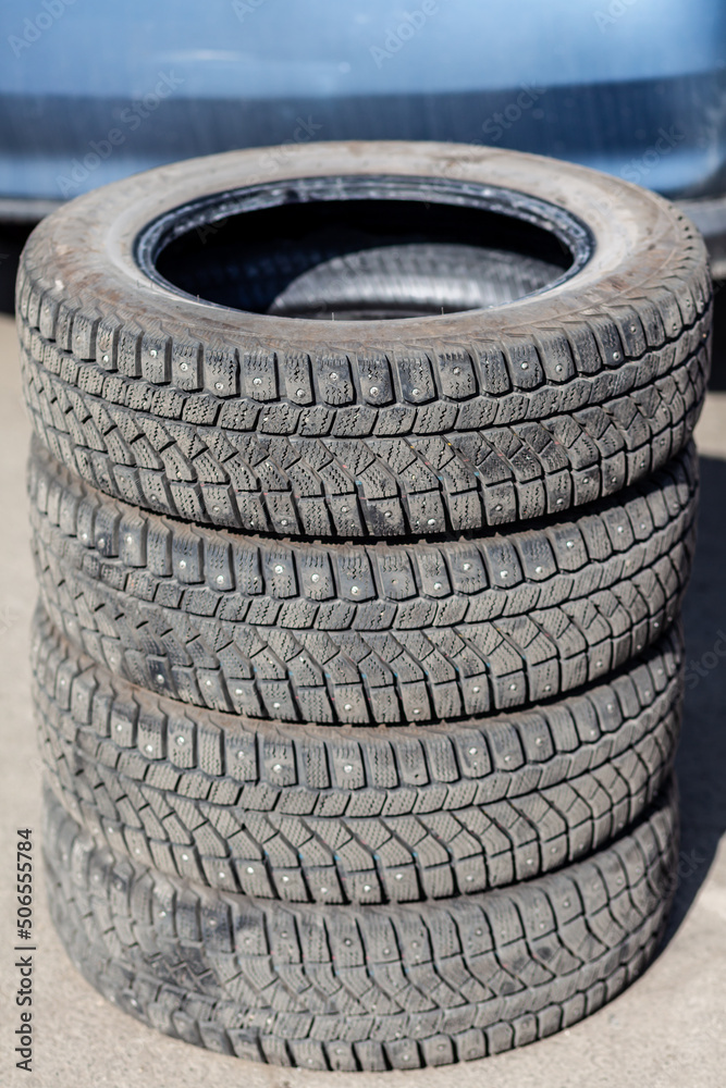 4 new tires that change tires in the auto repair service center, blurred background, the background is a new car in the stock blur for the industry, a four-wheeled tire set at a large warehouse 4 new tires that change tires in the auto repair service center, blurred background, the background is a new car in the stock blur for the industry, a four-wheeled tire set at a large warehouse