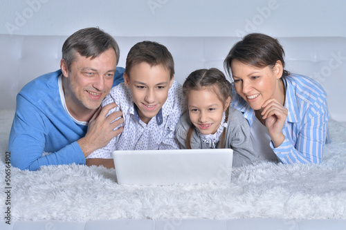 Tela Smiling family looking at a laptop