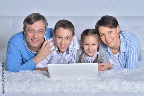 Murais de parede Smiling family looking at a laptop