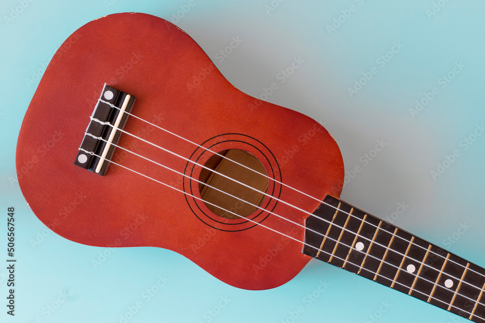 Fototapeta premium Musical instrument. Ukulelle on a blue background close-up