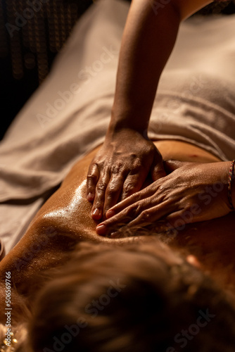  Thai massage at the spa. the masseur's hands are close-up doing an oil massage on a woman's body