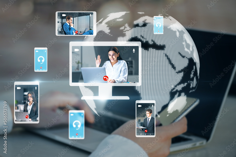 hands at workplace with devices and creative globe map with computer screens and creative video conference call between attractive young european businesspeople. Blurry backdrop. hands at workplace with devices and creative globe map with computer screens and creative video conference call between attractive young european businesspeople. Blurry backdrop.
