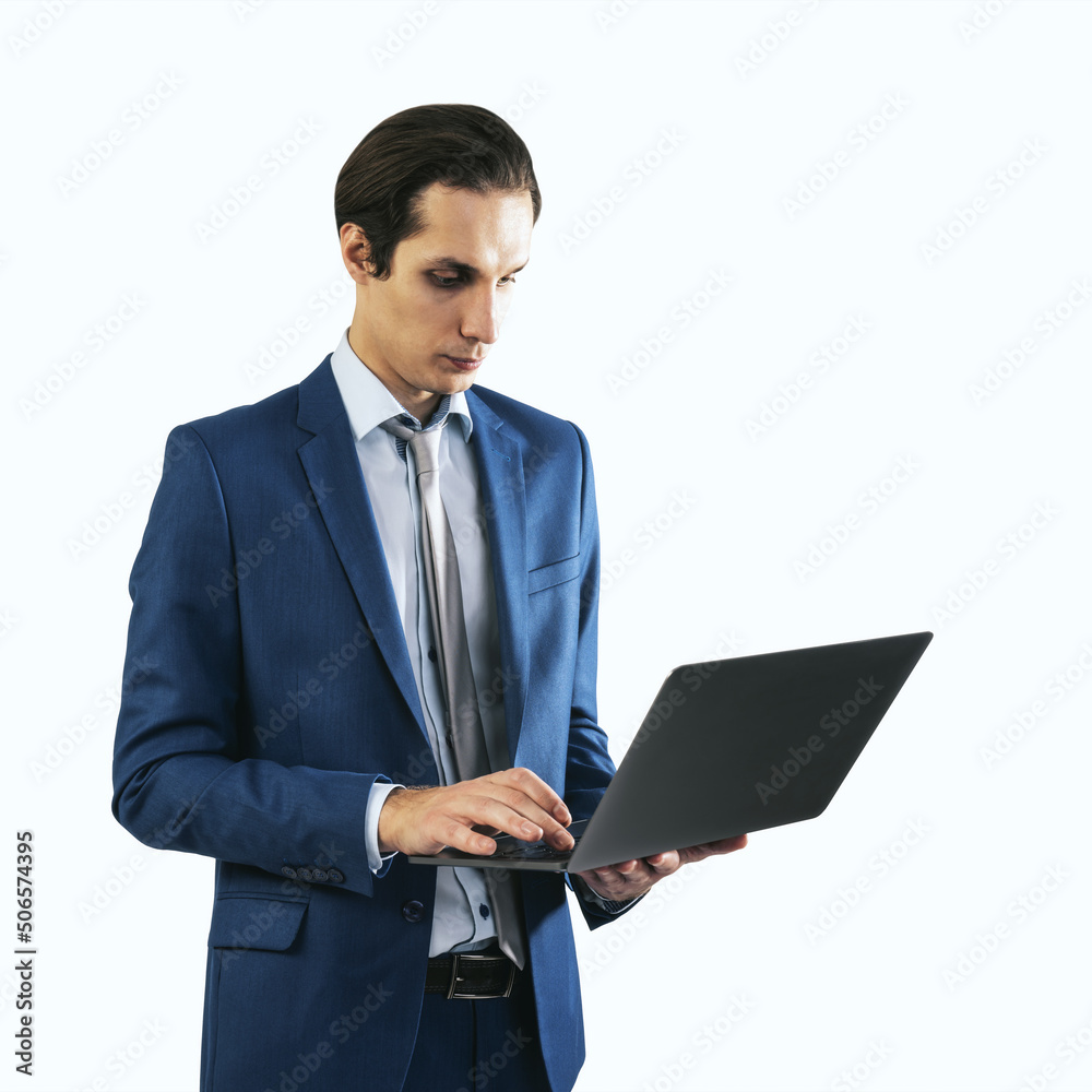 Young businessman in blue suit working with modern laptop, isolated on white background, close up Young businessman in blue suit working with modern laptop, isolated on white background, close up
