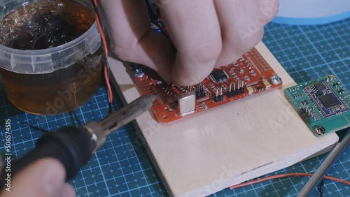 Soldering is done on the microchips in the factory with a soldering machine. electronic working hands.