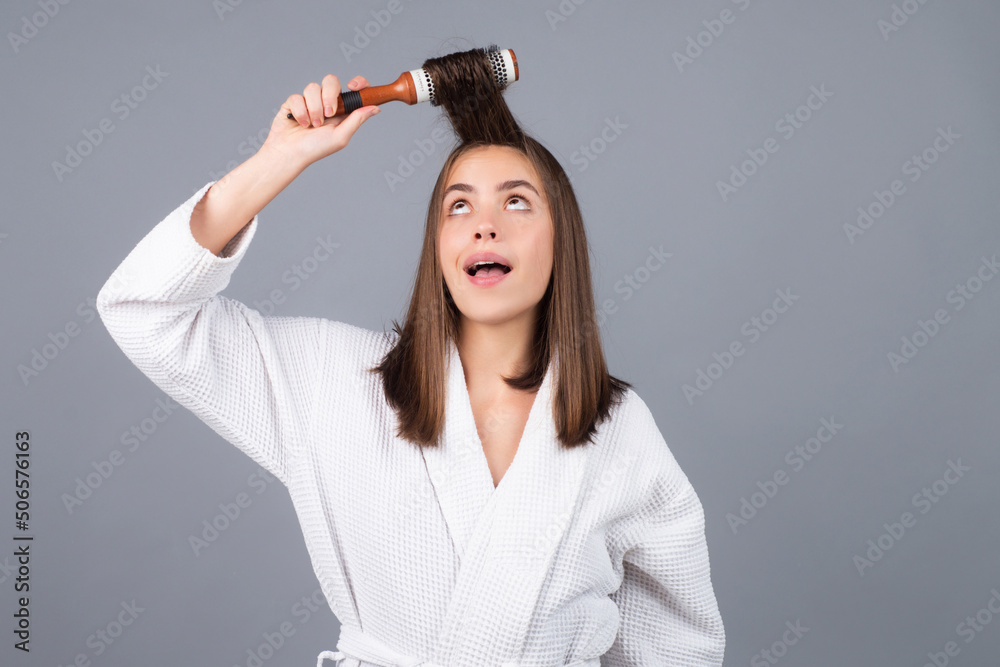 Surprised woman combing hair. Portrait of female model with a comb brushing hair. Girl with hairbrush, hair care and beauty. Surprised woman combing hair. Portrait of female model with a comb brushing hair. Girl with hairbrush, hair care and beauty.