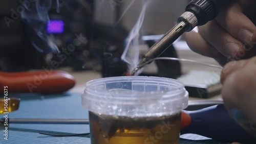 Soldering is done on the microchips in the factory with a soldering machine. electronic working hands.