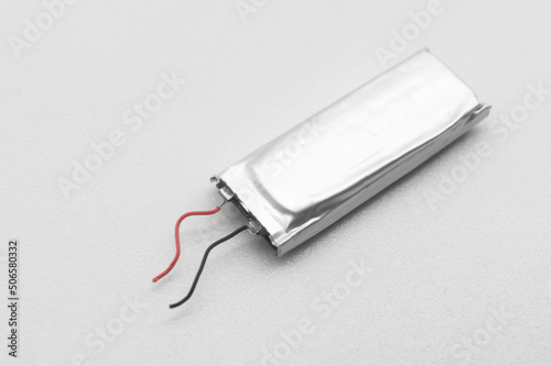 Lithium polymer battery on a white background. Compact small lithium battery for micro electronics. Rechargeable LIPO pack. Selective focus.  photo