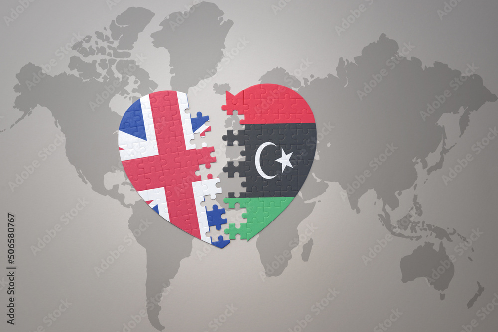 puzzle heart with the national flag of libya and great britain on a world map background. Concept. puzzle heart with the national flag of libya and great britain on a world map background. Concept.