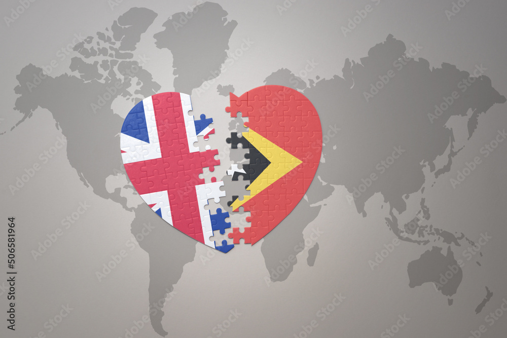 puzzle heart with the national flag of east timor and great britain on a world map background. Concept. puzzle heart with the national flag of east timor and great britain on a world map background. Concept.