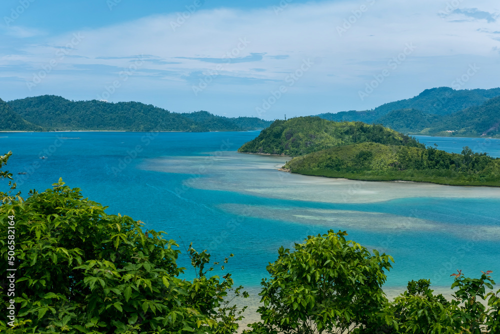 The view of island cover with turquoise sea and blue sky background at Mandeh, South Pesisir, West Sumatera