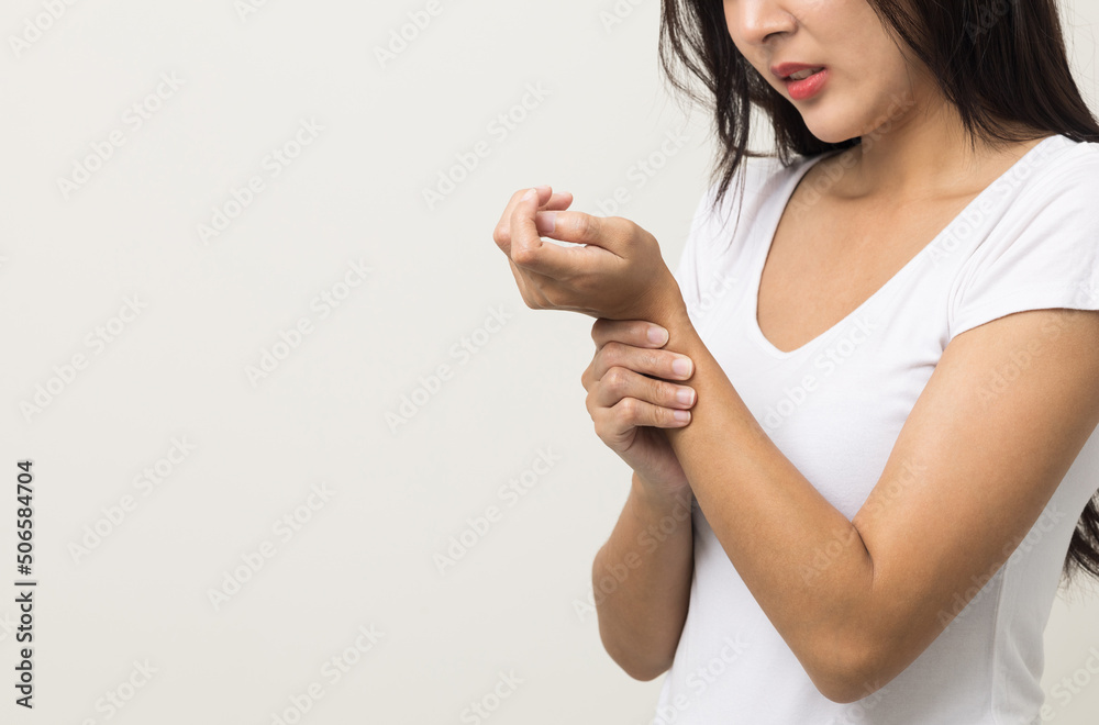 A woman has an inflamed wrist because she is overworked. She massaged her wrists to soothe and relax. Shot on isolated white background. A woman has an inflamed wrist because she is overworked. She massaged her wrists to soothe and relax. Shot on isolated white background.
