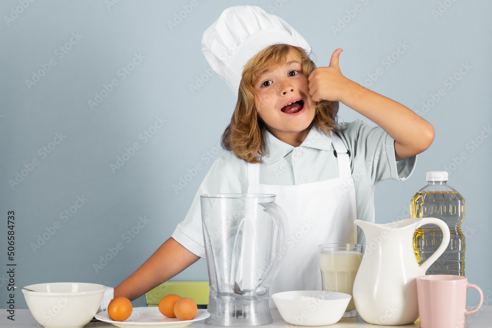 Child chef dressed cook baker apron and chef hat isolated on studio background. Healthy nutrition kids food. Child chef dressed cook baker apron and chef hat isolated on studio background. Healthy nutrition kids food.