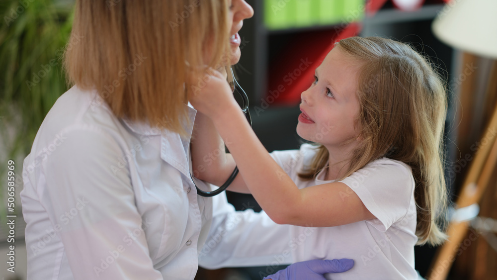 Doctor pediatrician communicates with little girl in clinic Doctor pediatrician communicates with little girl in clinic