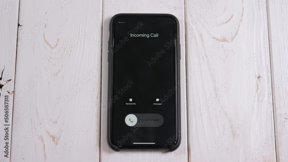 Closeup of an call on the phone screen on a light wooden