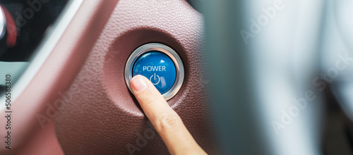 Foto Finger press a car ignition button or START engine inside modern electric automobile