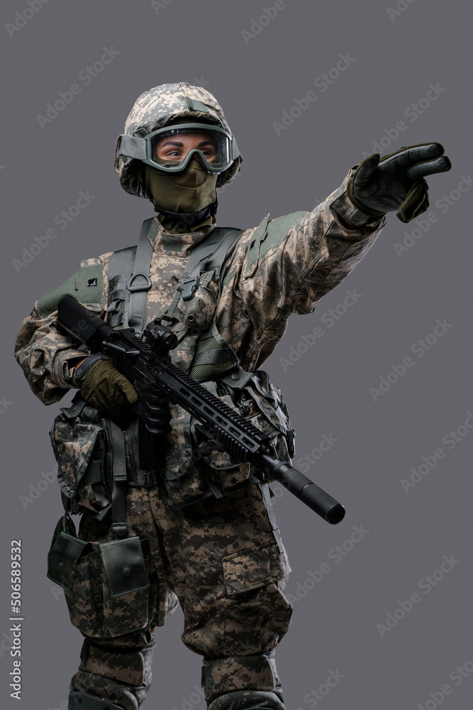 Shot of militant woman dressed in uniform with helmet and eyewear commanding attack.