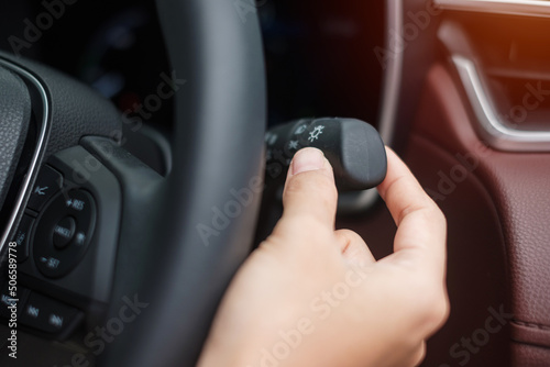 hand turn on light switch inside car. Safety transportation concept © Jo Panuwat D