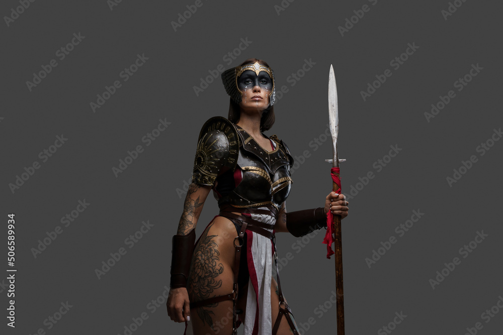 Portrait of ancient amazon with spear dressed in armour against grey background. Portrait of ancient amazon with spear dressed in armour against grey background.