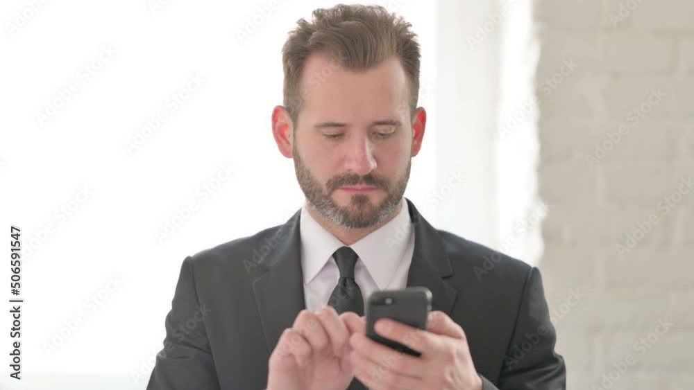 Young Businessman Browsing Internet on Smartphone Young Businessman Browsing Internet on Smartphone
