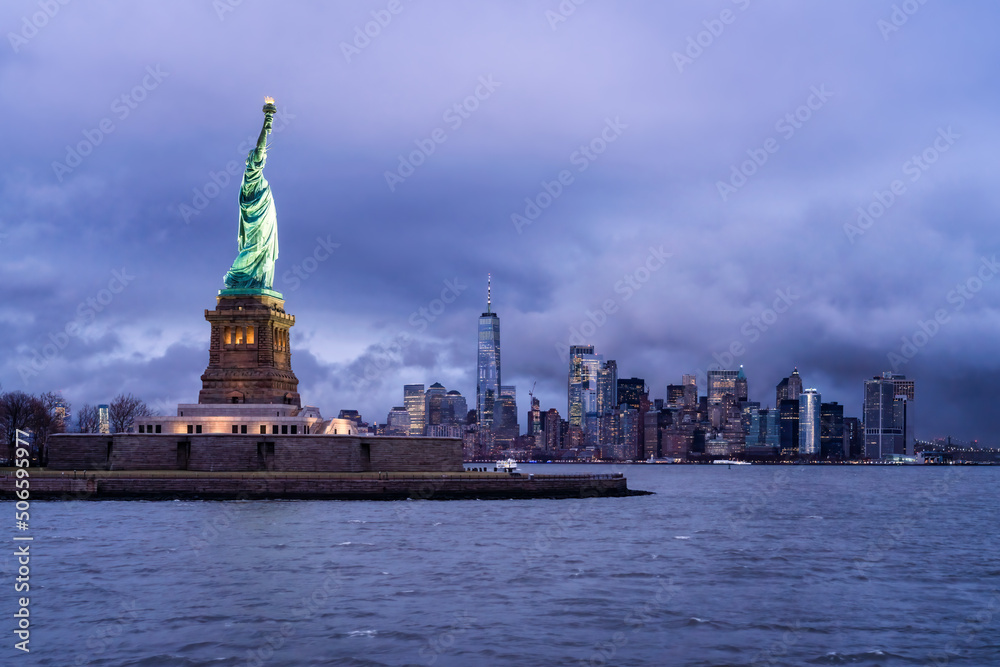 Statue of Liberty at night with Manhattan skyline in the background, New York City, USA Statue of Liberty at night with Manhattan skyline in the background, New York City, USA