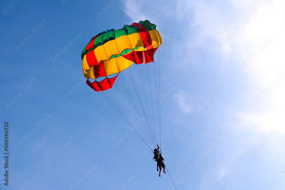 Parasailing in blue sky. Sports, active leisure, travel, vacation concept Parasailing in blue sky. Sports, active leisure, travel, vacation concept