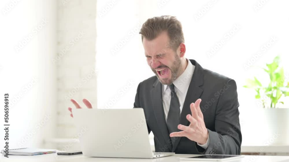 Young Businessman Feeling Angry While using Laptop Young Businessman Feeling Angry While using Laptop