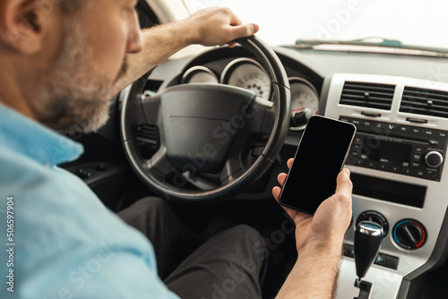 Driver man using smartphone with empty screen driving car © Prostock-studio