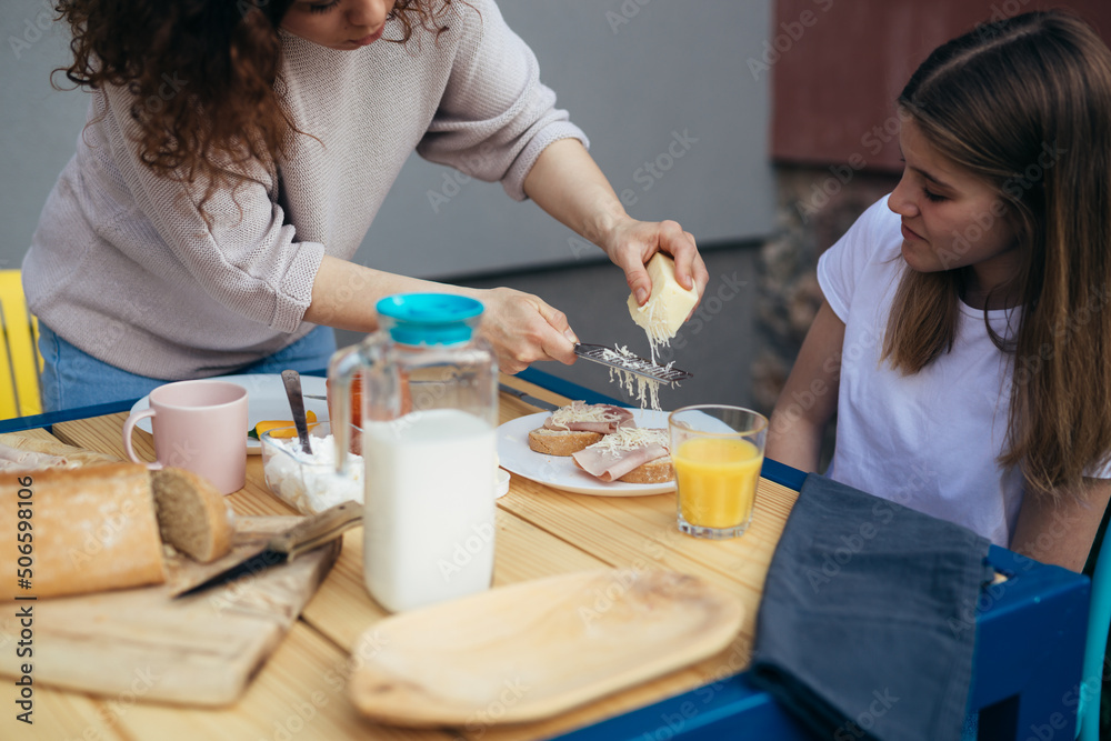 mother and daughter breakfast together at home in backyard mother and daughter breakfast together at home in backyard