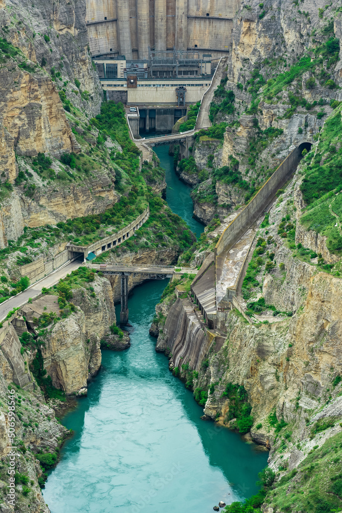 Fototapeta premium view of the lower part of the arch dam with a spillway in the canyon