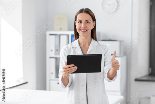 medicine, healthcare and profession concept - smiling female doctor with tablet pc computer showing thumbs up at hospital