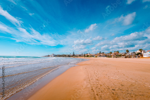 Fototapeta Naklejka Na Ścianę i Meble -  Sandy beach by the sea at Donnalucata, Sicily, with blue skies and clouds