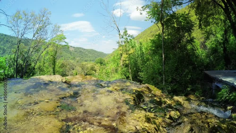 KRKA NATIONAL PARK, CROATIA - SEPTEMBER 5, 2021: Rocky water stream and view on the green hills in Krka National Park, Croatia. 4K, Ultra-wide, Audio KRKA NATIONAL PARK, CROATIA - SEPTEMBER 5, 2021: Rocky water stream and view on the green hills in Krka National Park, Croatia. 4K, Ultra-wide, Audio