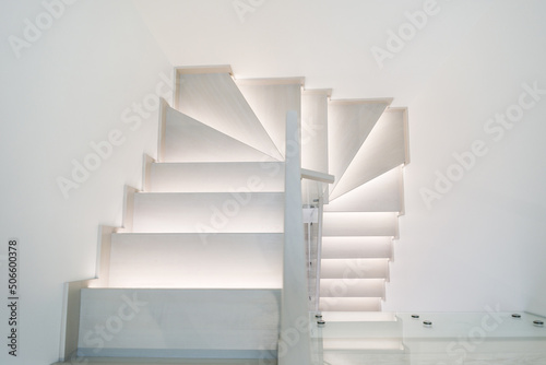 Illuminated wooden staircase in duplex apartment