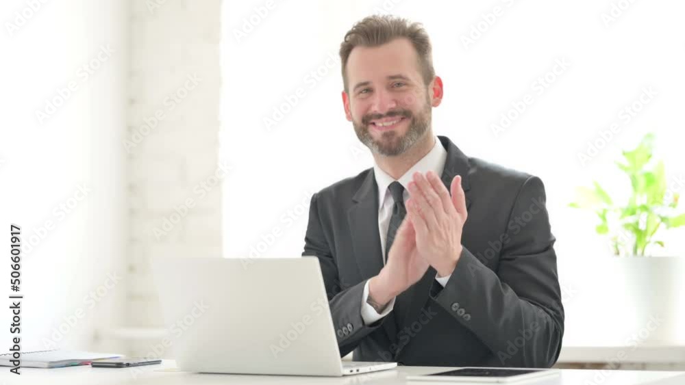 Happy Young Businessman Clapping while using Laptop Happy Young Businessman Clapping while using Laptop