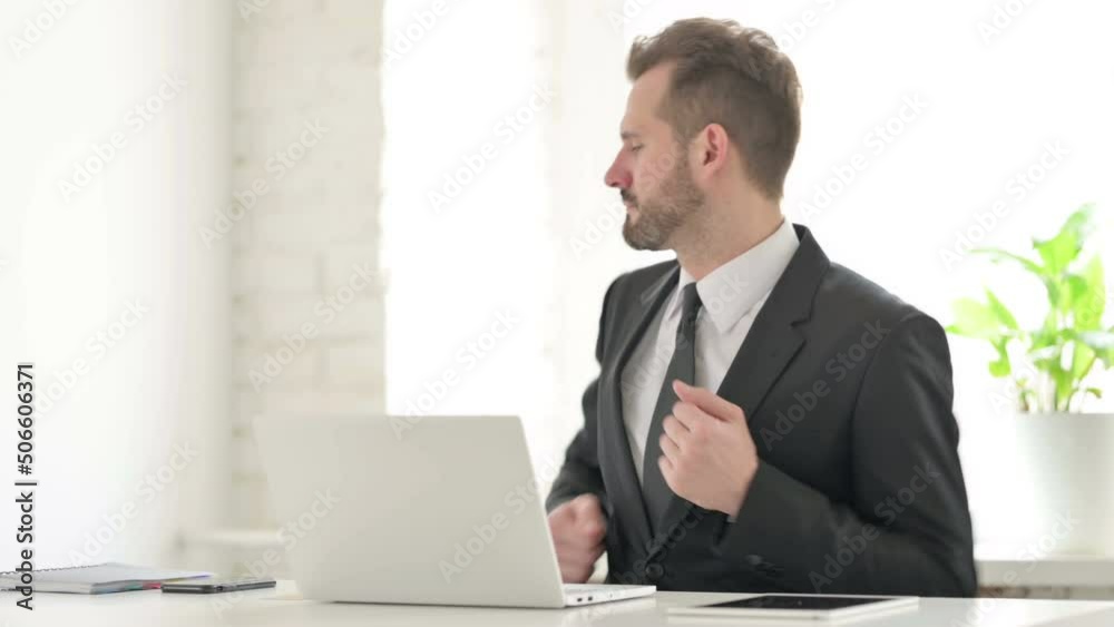 Young Businessman Dancing while using Laptop in Office Young Businessman Dancing while using Laptop in Office