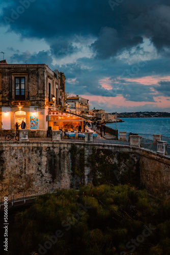 Panoramic view of Ortigia with Fonte Aretusa (Fountain of Arethusa) and Lungomare Alfeo (Alphaeus waterfront) during sunset photo