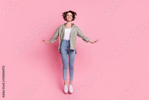 Full size photo of excited crazy girl jumping toothy smile spend pastime isolated on pink color background