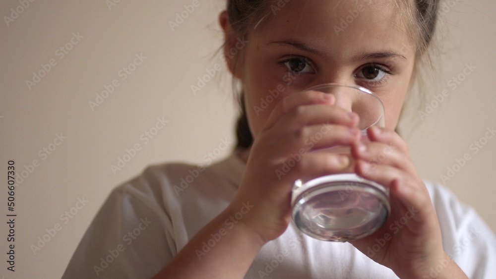 child drinking water. little girl in the kitchen drinks water from a glass cup. problem of shortage of drinking water in the world concept. kid lifestyle drinking clean water from a glass child drinking water. little girl in the kitchen drinks water from a glass cup. problem of shortage of drinking water in the world concept. kid lifestyle drinking clean water from a glass