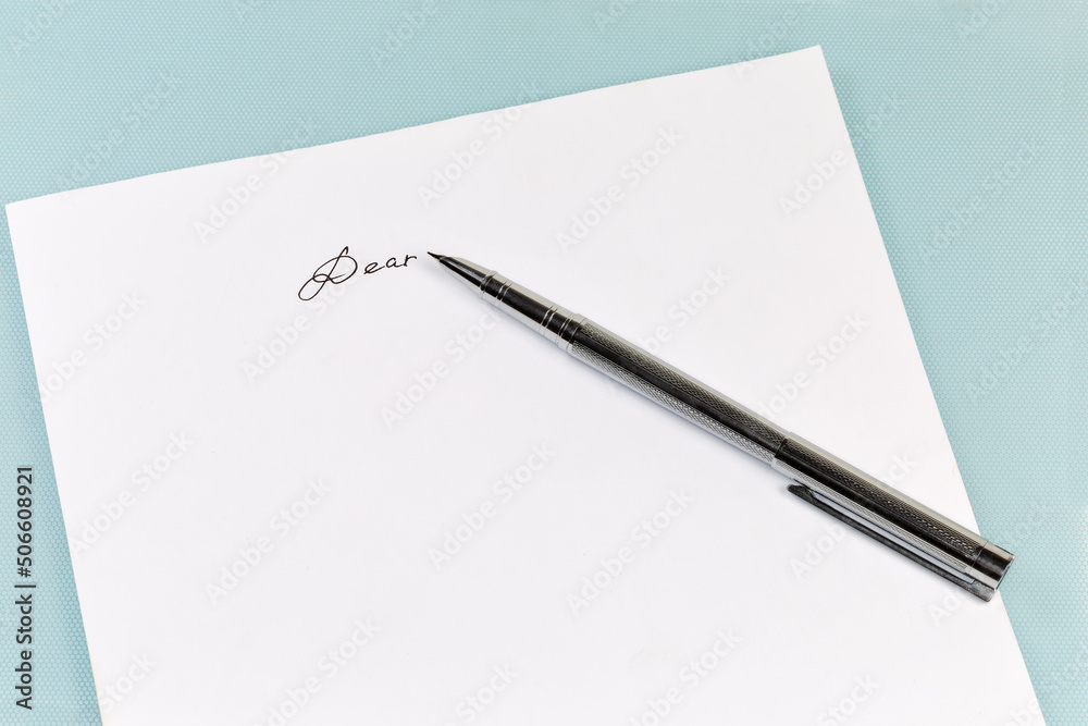 Fountain pen lie on paper sheet with written salutation word Fountain pen lie on paper sheet with written salutation word
